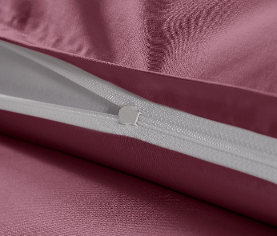 Detailný záber na zips na vínových bavlnených saténových obliečkach nadmernej veľkosti.