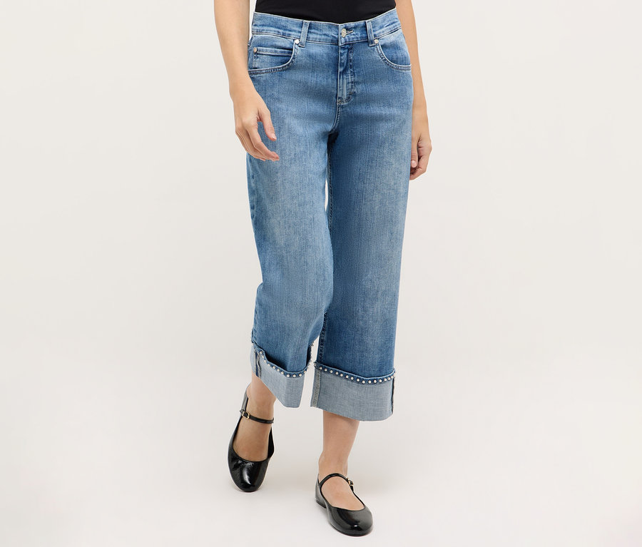 Žena má na sebe modré rifle Angels Denim »Linn Cool« a čierne topánky Mary Jane.