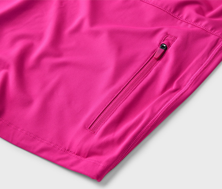Detail ružovej bundy so vreckom na zips.