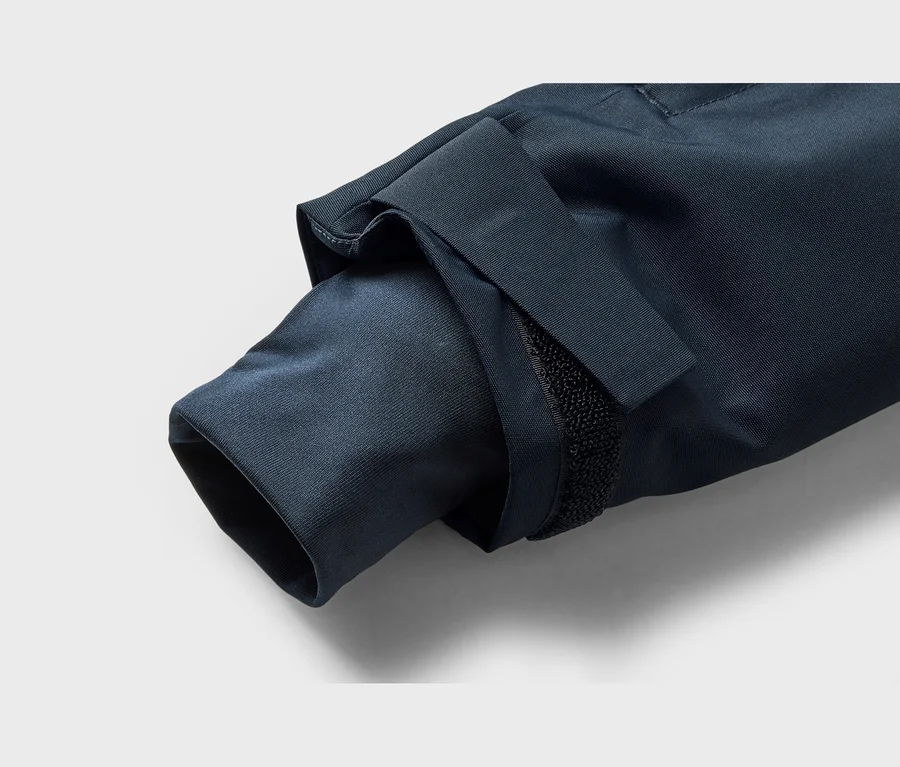 Detail rukáva tmavomodrej bundy s nastaviteľnou manžetou na suchý zips.