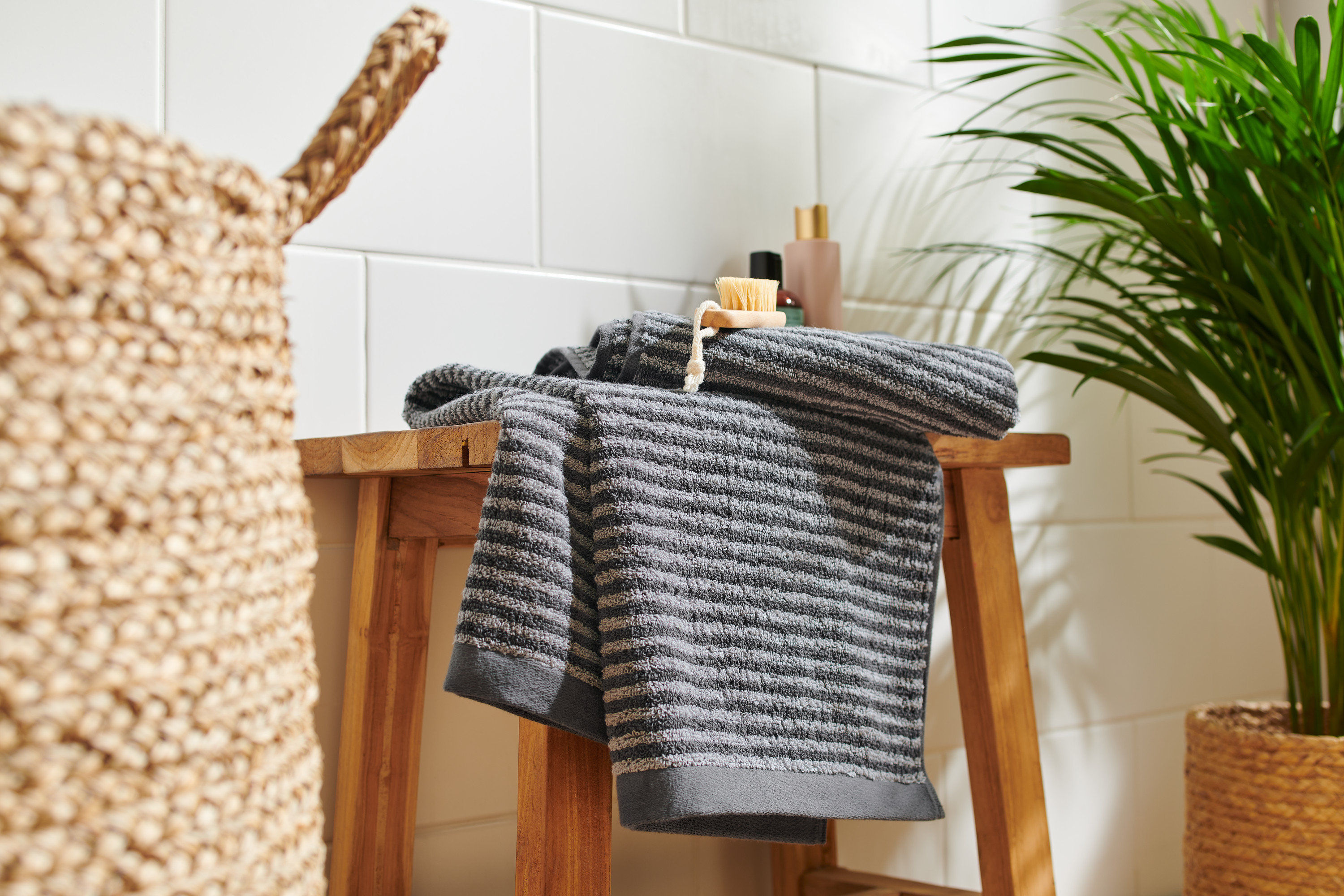 Na drevenej stoličke ležia dva kvalitné antracitové uteráky.