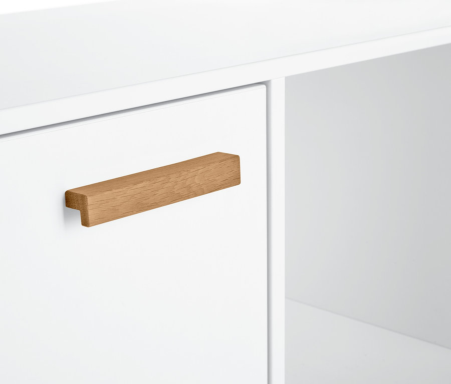 Detail bielej odkladacej skrinky s drevenou úchytkou.