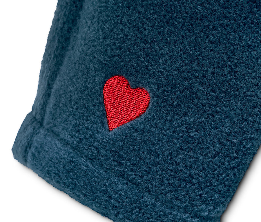 Detail modrej flísovej bundy s recyklovaného materiálu s červeným srdcom.