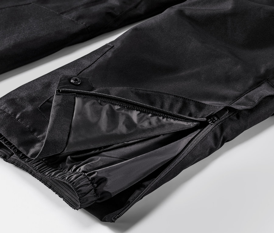 Detail lyžiarskych nohavíc s rozopnutým zipsom.