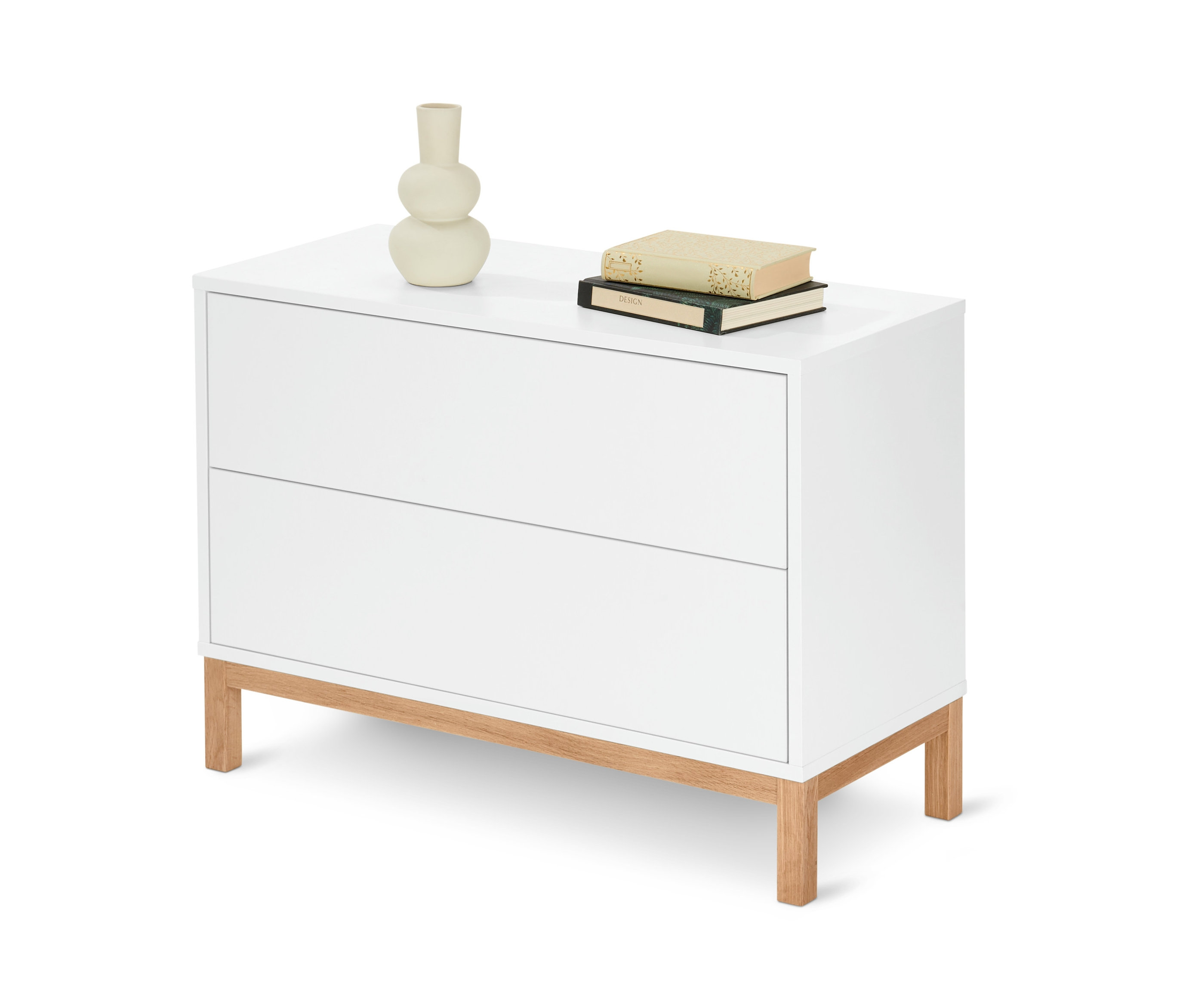 Biela komoda s plytkými zásuvkami, na vrchu váza a knihy.