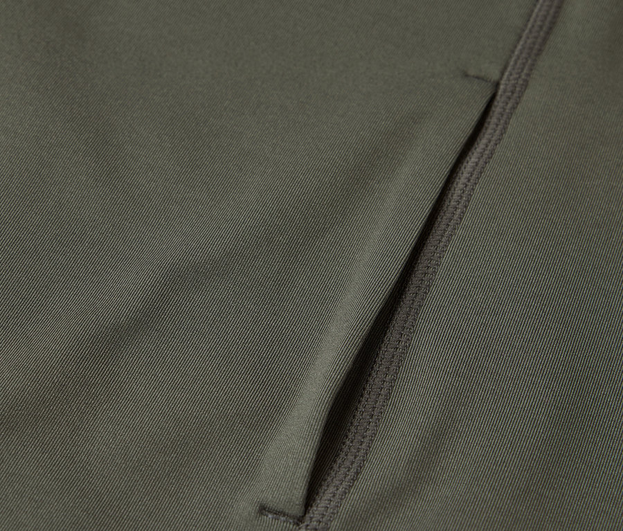 Detailný záber na olivovozelenú látku s vreckom na zips.