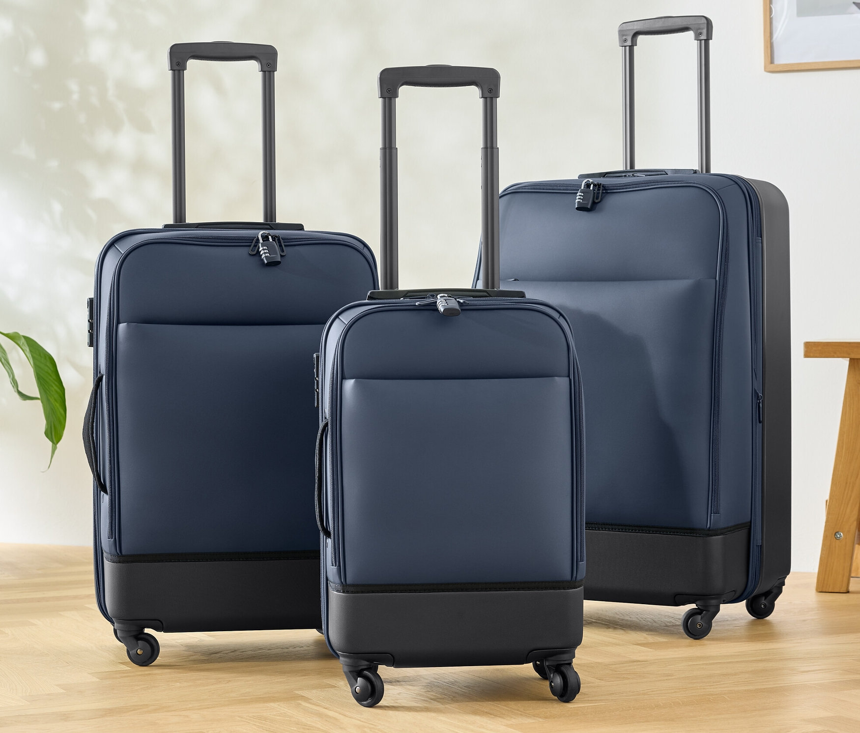 Tri hybridné kufre (malý, stredný a veľký) stoja na drevenej podlahe.