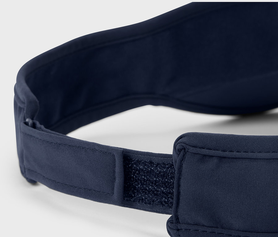 Detailný pohľad na námornícky modrý bežecký šilt s nastaviteľným zapínaním na suchý zips.