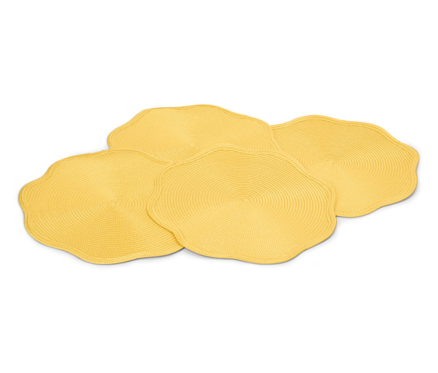 Štyri žlté, okrúhle prestierania s vlnitým okrajom ležia na sebe.