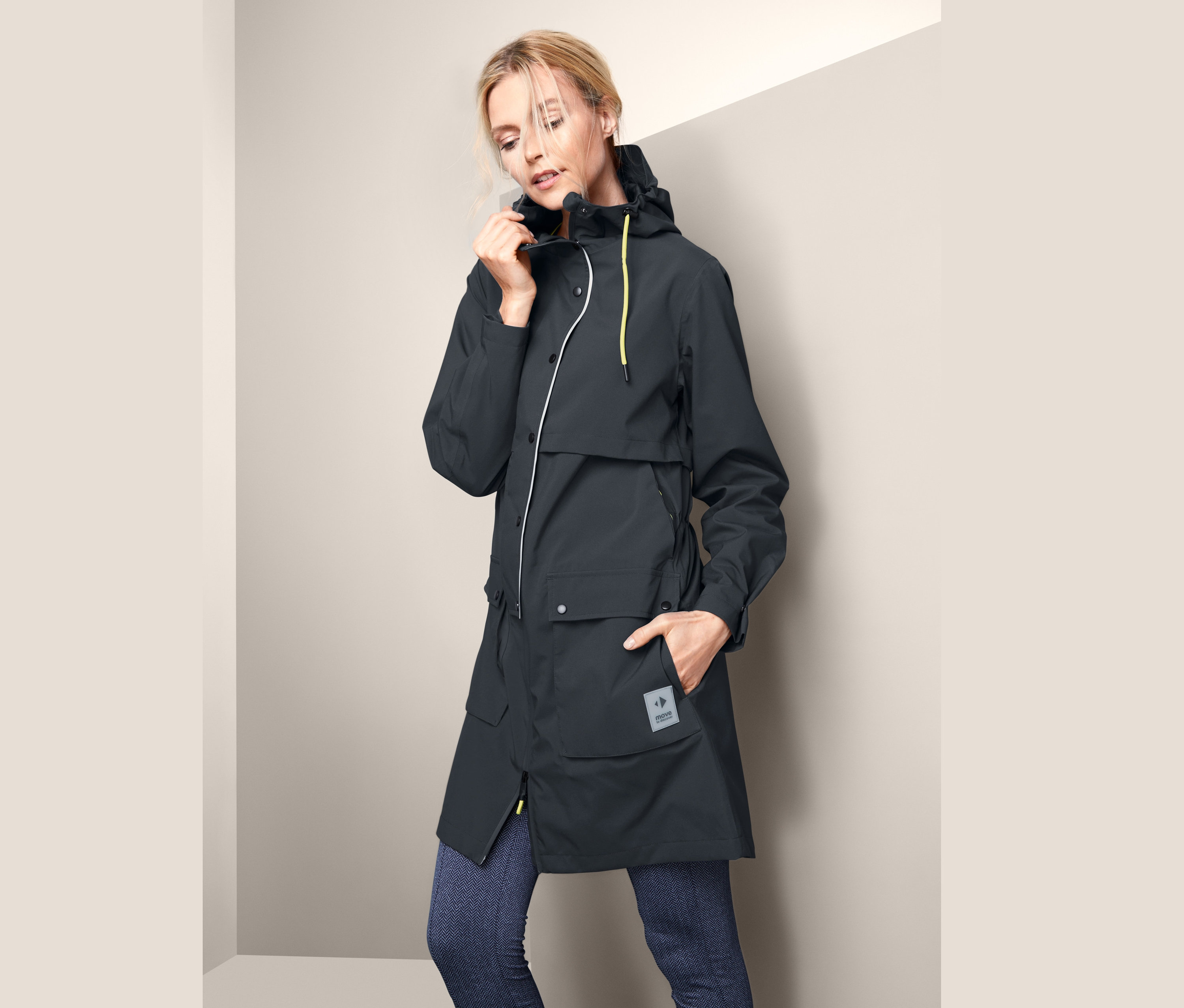 Žena si upravuje funkčnú parku do dažďa.