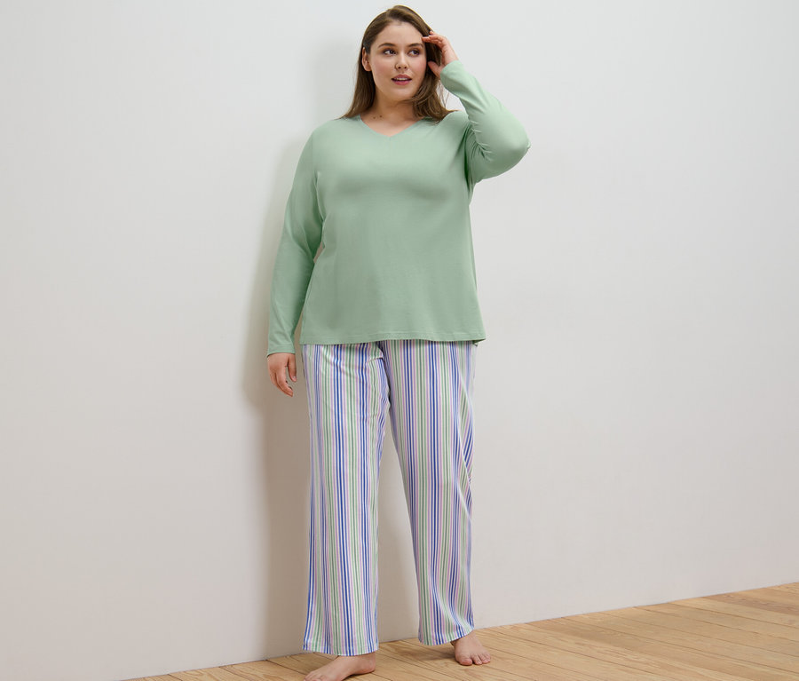 Žena má na sebe pyžamo a stojí v miestnosti.