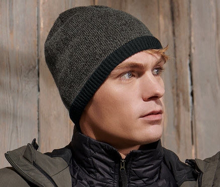 Muž má na sebe pletenú čiapku a bundu.
