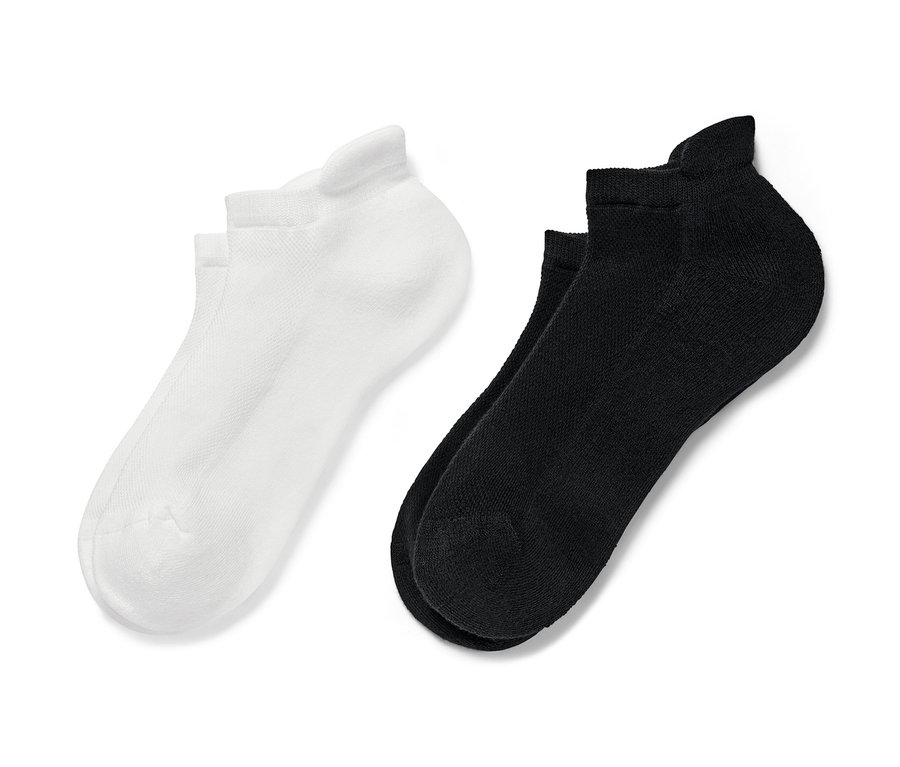 Dva páry krátkych športových ponožiek, jedny čierne a jedny biele.