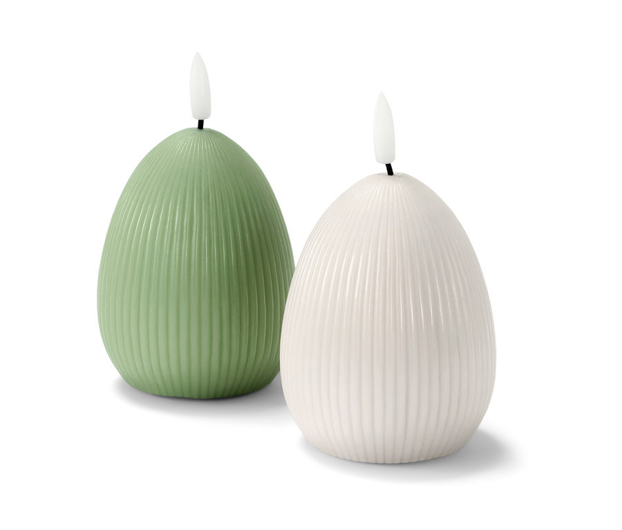 Dve LED sviečky z pravého vosku, jedna zelená a jedna biela, stoja vedľa seba na bielom pozadí.