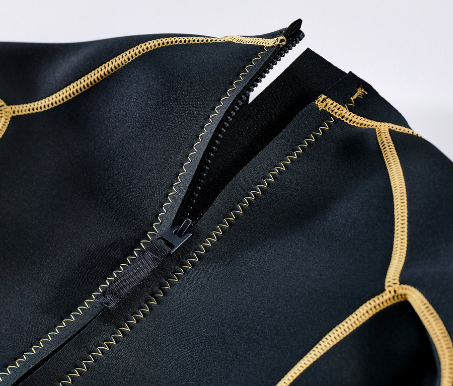 Detail detského neoprenového obleku s rozopnutým zipsom a žltým lemovaním.