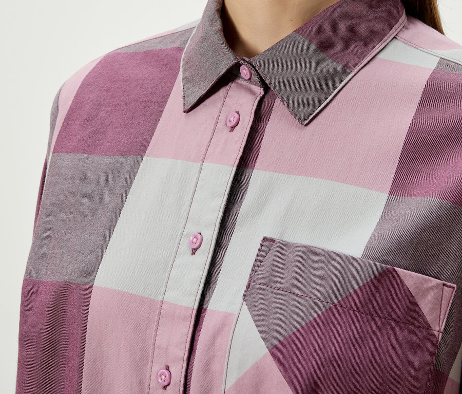 Detail dámskej kockovanej košele s gombíkmi a náprsným vreckom.
