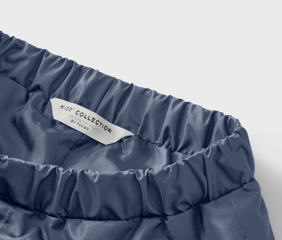 Detail modrých detských nohavíc s elastickým pásom a štítkom s nápisom Kids' Collection.