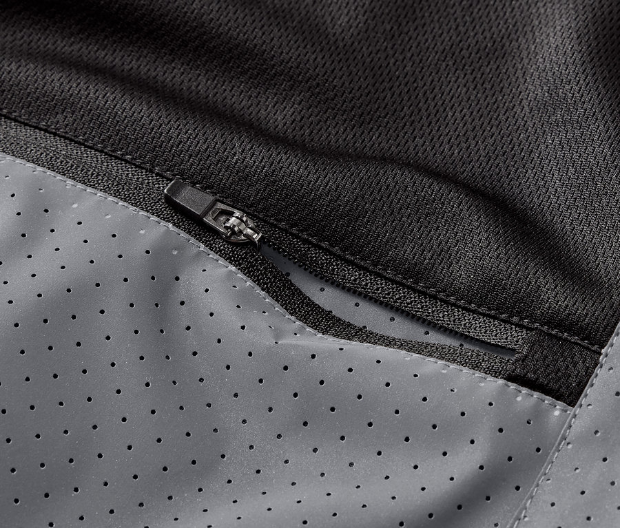 Detailný záber na vrecko na zips na reflexnej bežeckej veste.