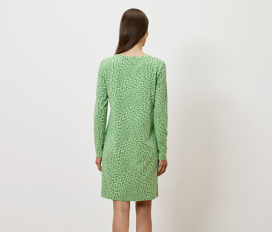 Pohľad zozadu na ženu v zelených šatách s dlhým rukávom.