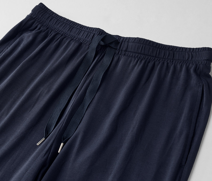 Detailný záber na tmavomodré tepláky so šnúrkou.