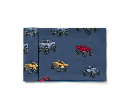 Látka s potlačou monster truckov v sivej, červenej a žltej farbe na modrom pozadí.