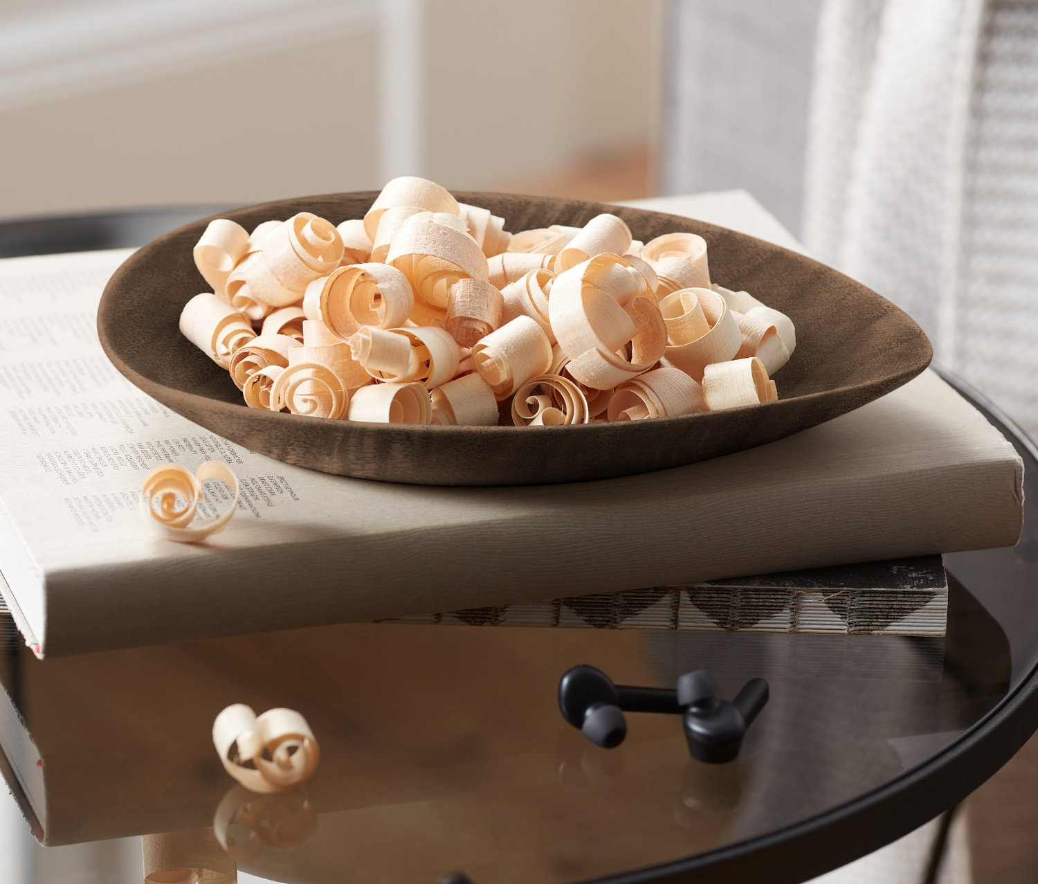 Miska hoblín z dreva borovice limbovej, 25 g, na knihe na stolíku.