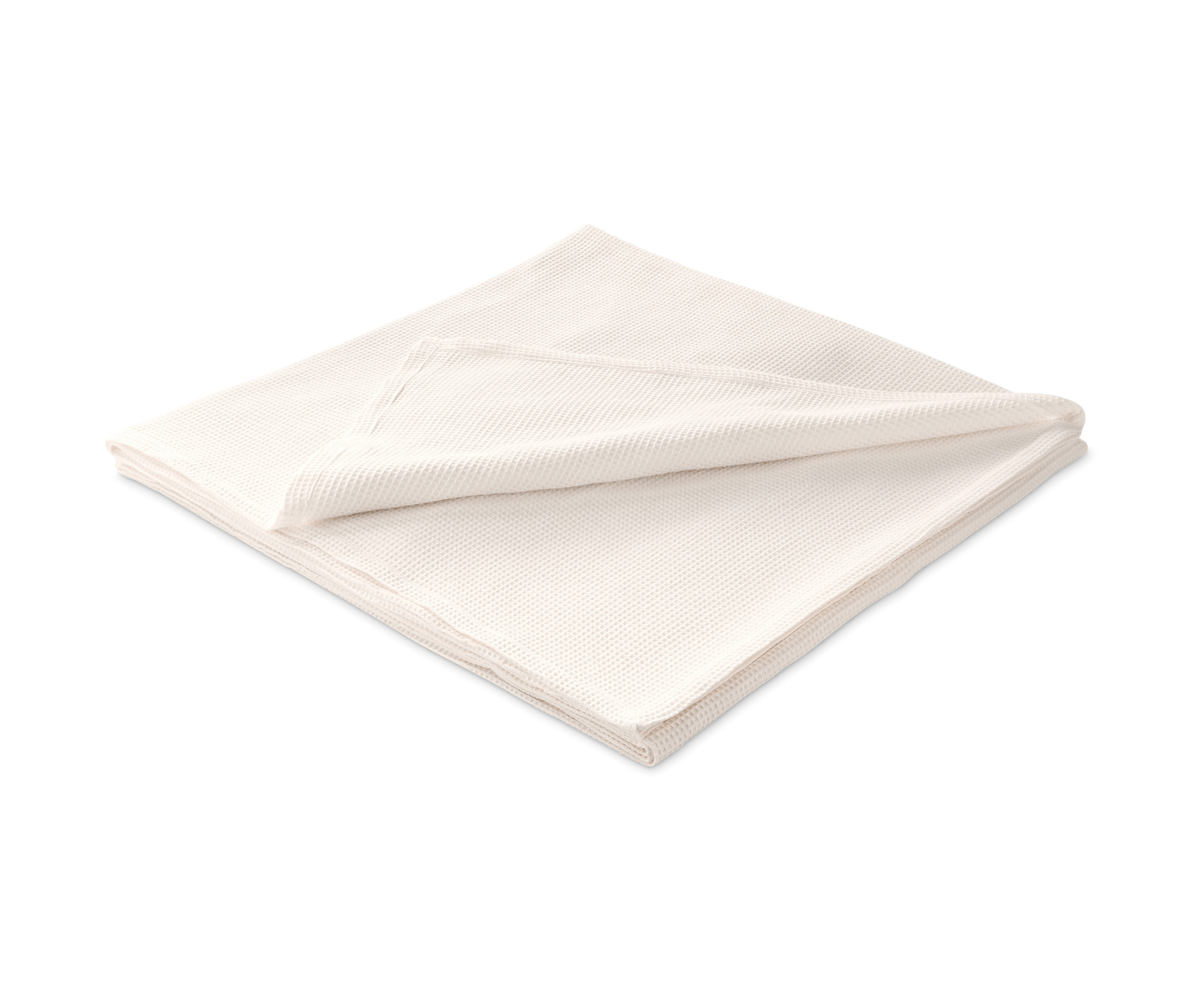 Zložená prikrývka na posteľ.