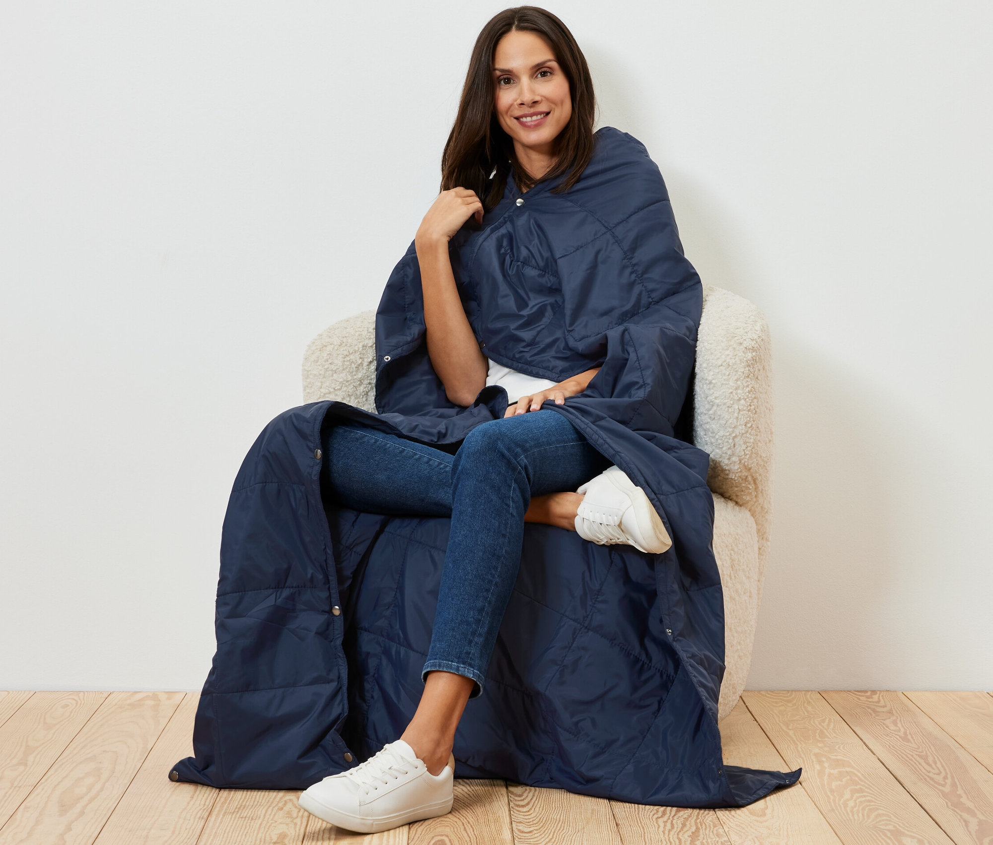 Žena sedí v kresle a je zabalená do ultraľahkej cestovnej deky.