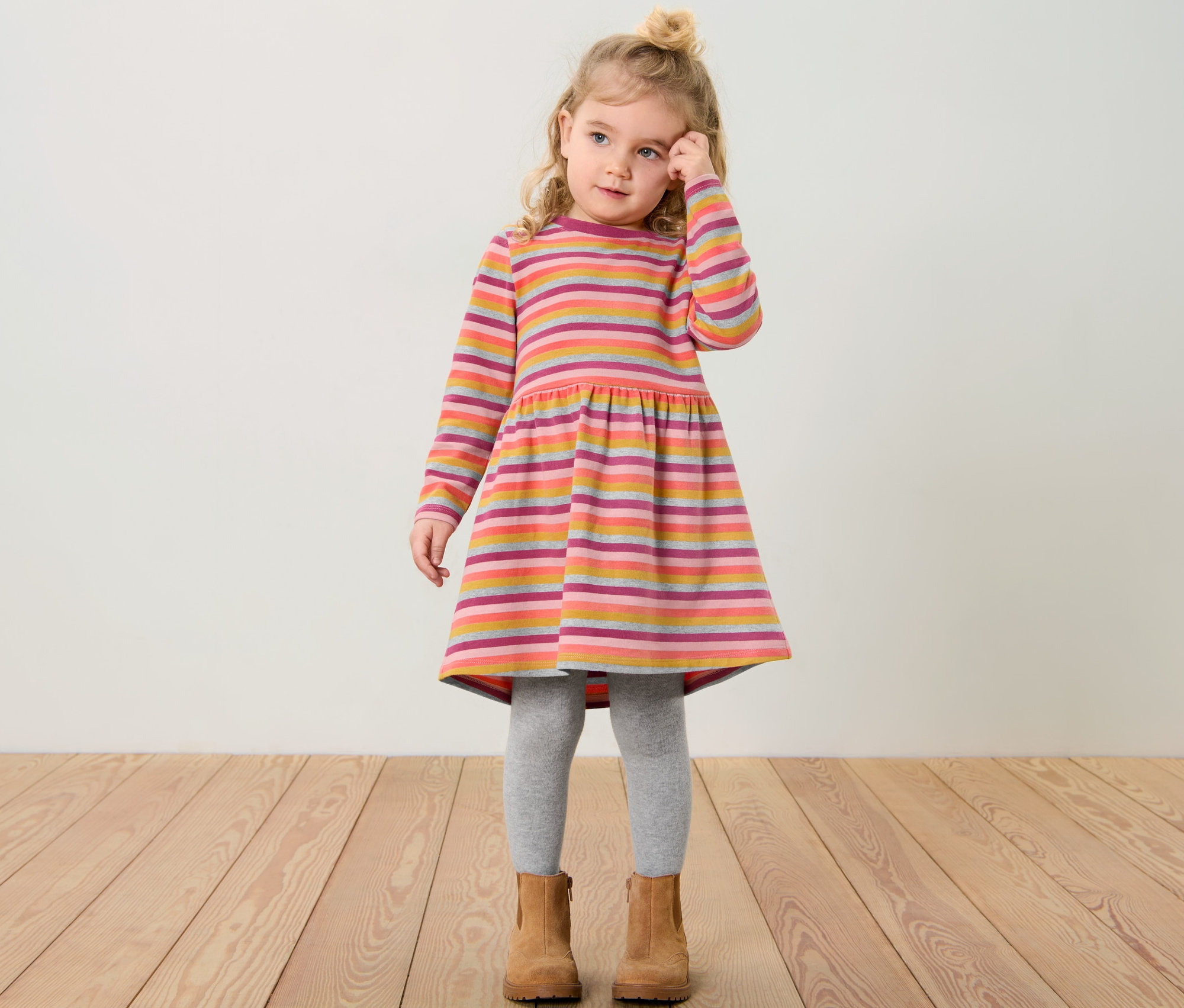 Dievčatko v detských teplákových šatách s pruhovaným vzorom.