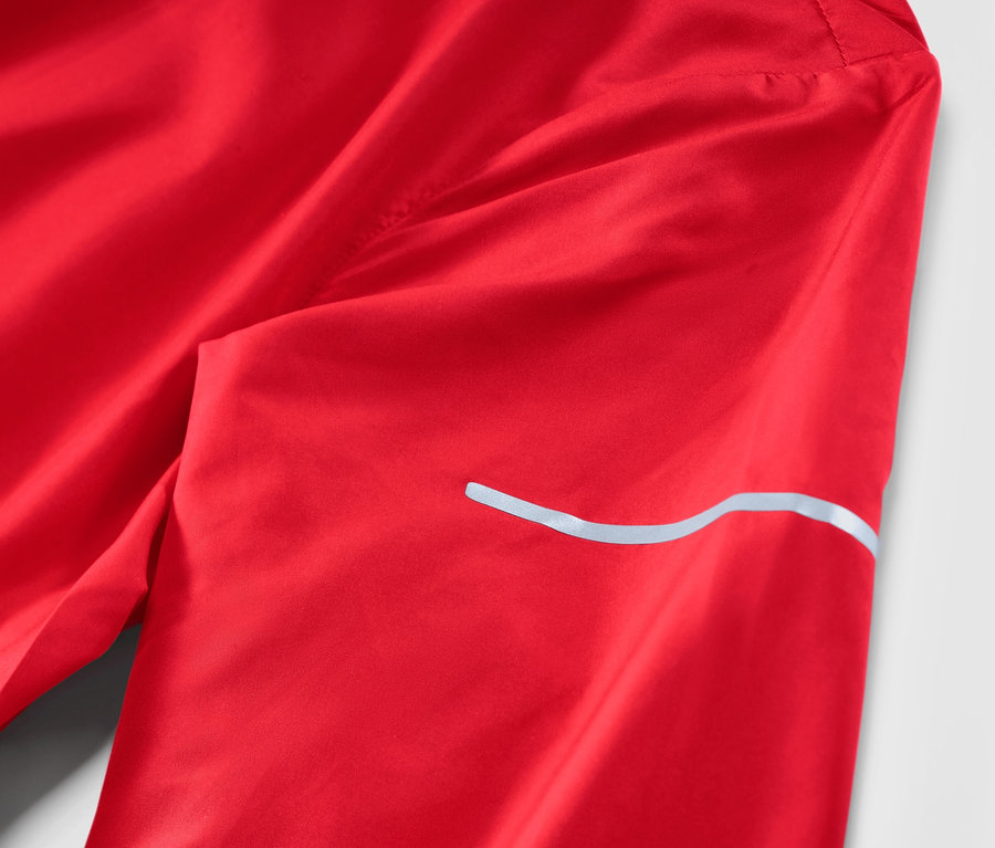 Detail červenej ľahkej bežeckej bundy.