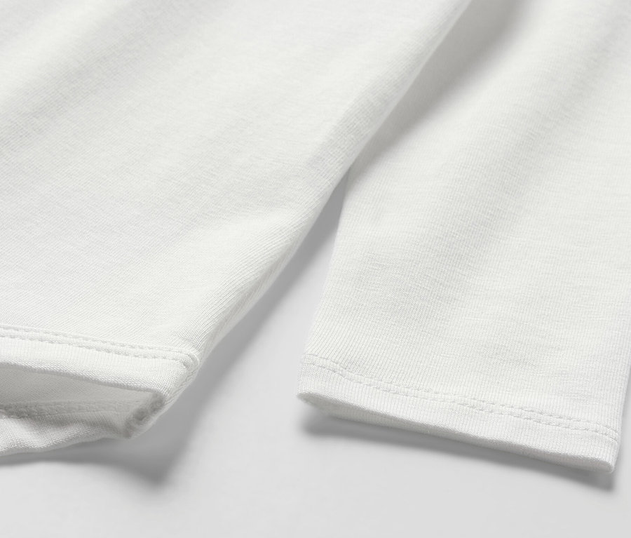 Detail bieleho dojčenského body s dlhým rukávom.