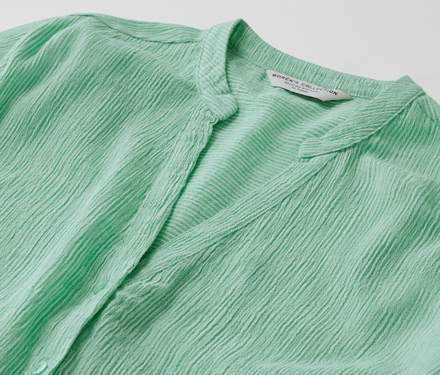 Detail zelenej pásikavej tuniky.