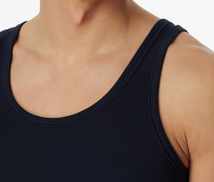 Muž má na sebe modré tielko SCHIESSER s rebrovaným úpletom.