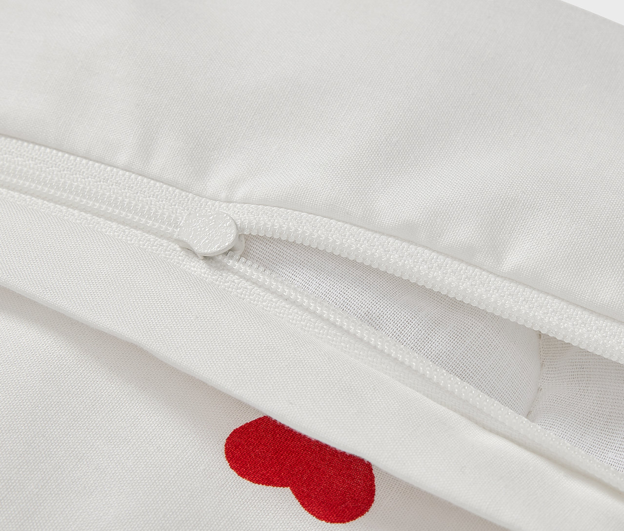 Detail detskej renforcé posteľnej bielizne, 100 x 135 cm, s červenými srdiečkami a zipsom.