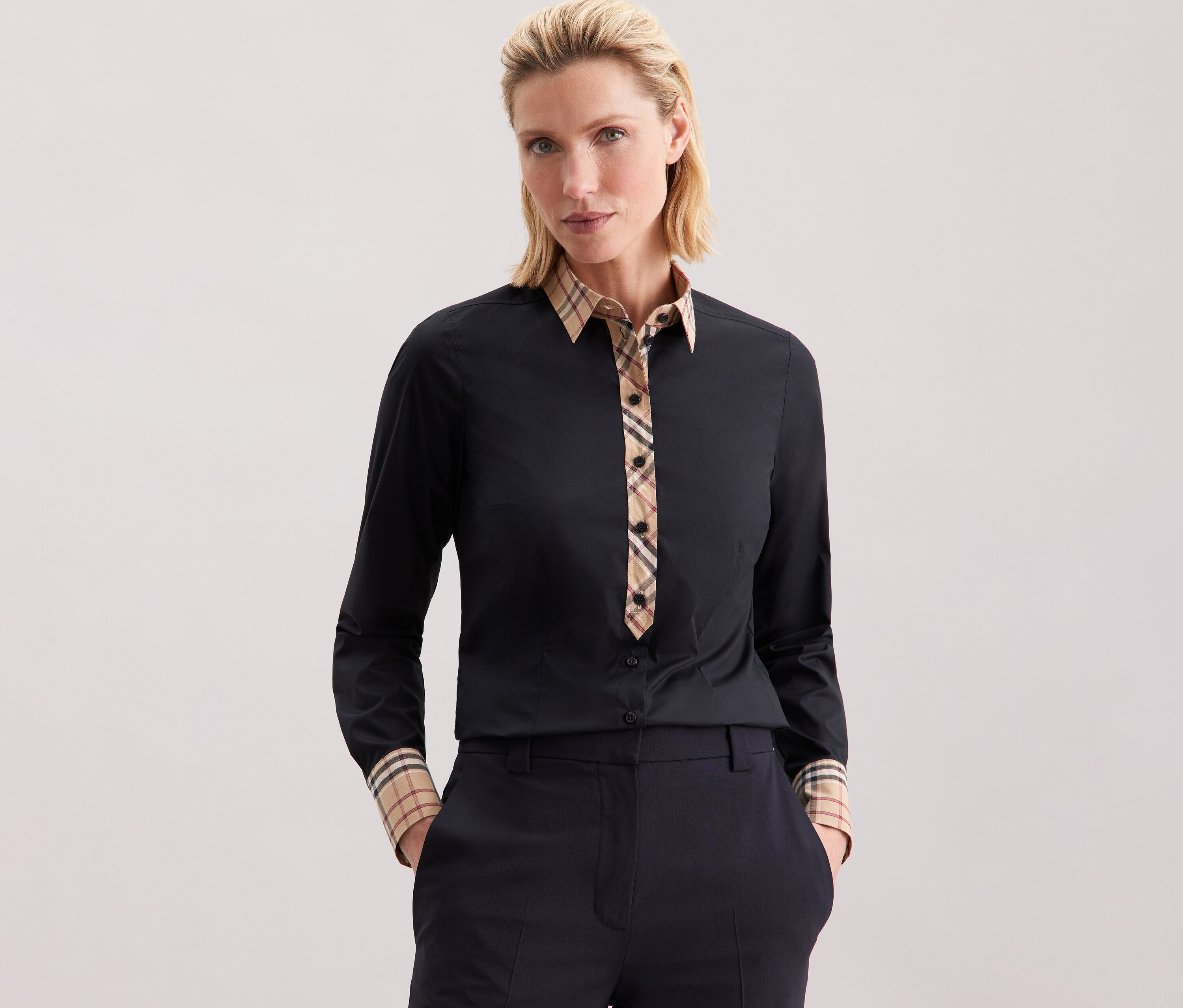 Žena má na sebe popelínovú blúzku Seidensticker s károvaným detailom.