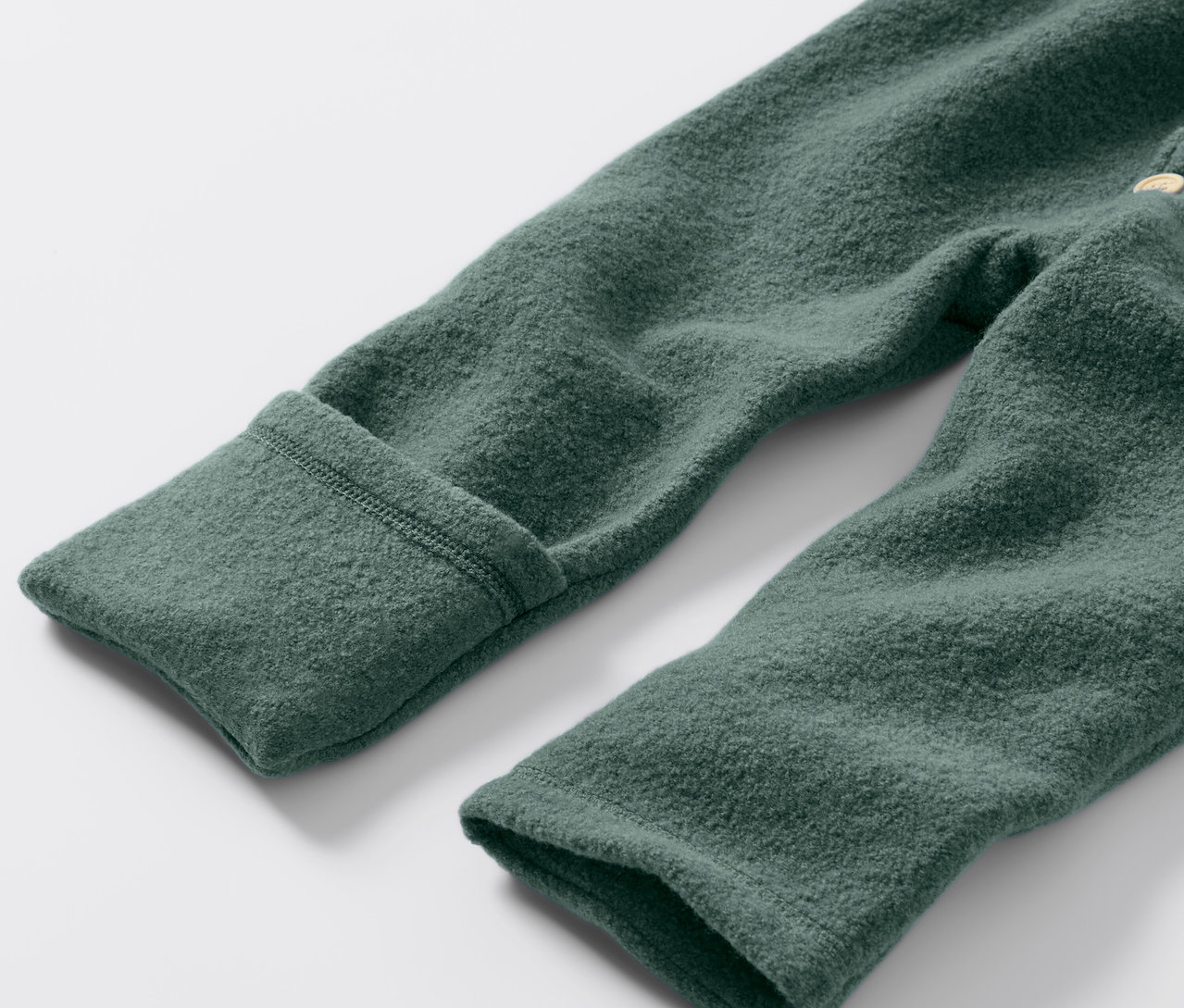 Detail zeleného detského vychádzkového overalu s vlnou merino.