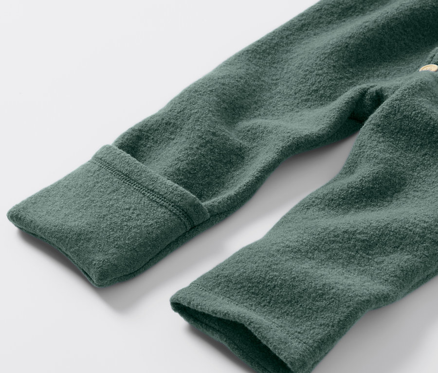 Detail zeleného detského vychádzkového overalu s vlnou merino.