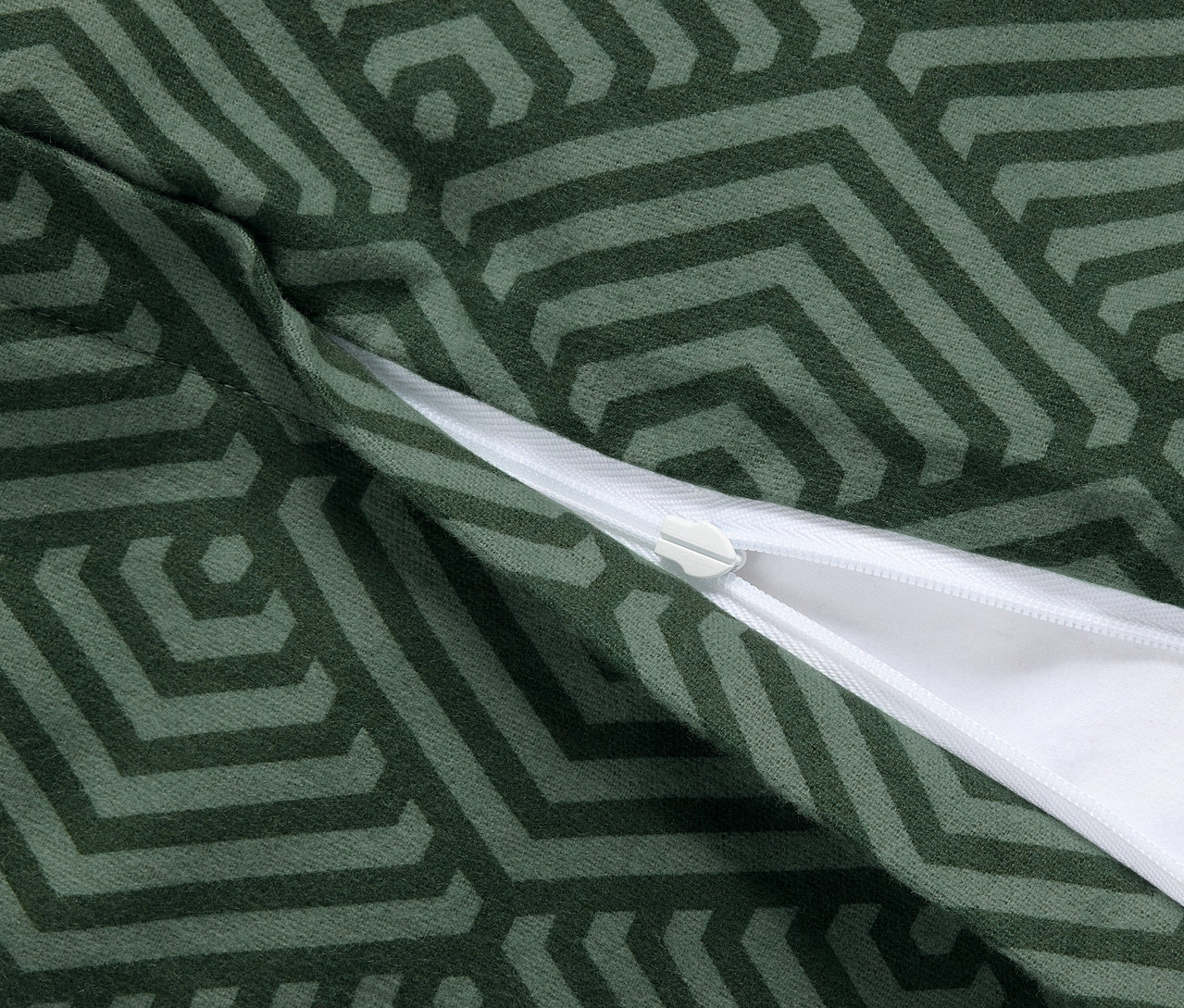 Detailný záber na dve zelené flanelové obliečky na vankúše s geometrickým vzorom a zipsom.