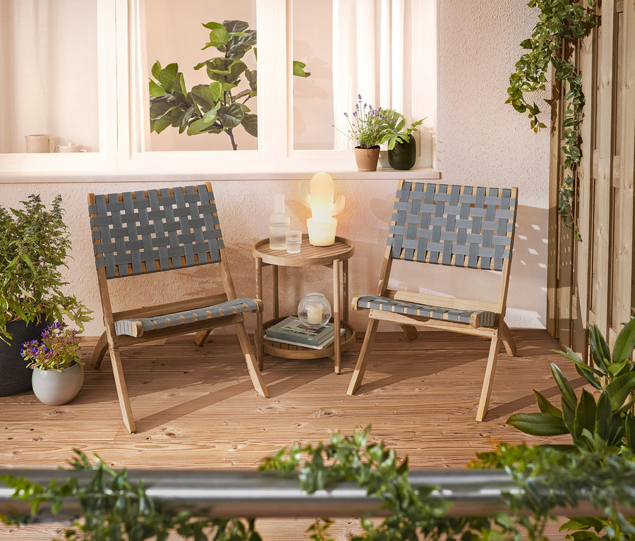 Na terase stoja dve pletené stoličky a príručný stolík.