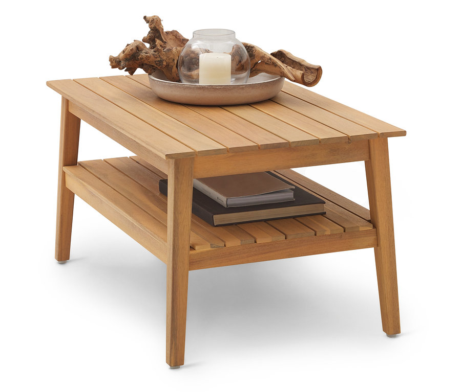 Svetlohnedý drevený konferenčný stolík s dvoma úrovňami. Na hornej úrovni je miska so sviečkou a naplaveným drevom, na spodnej úrovni sú knihy.