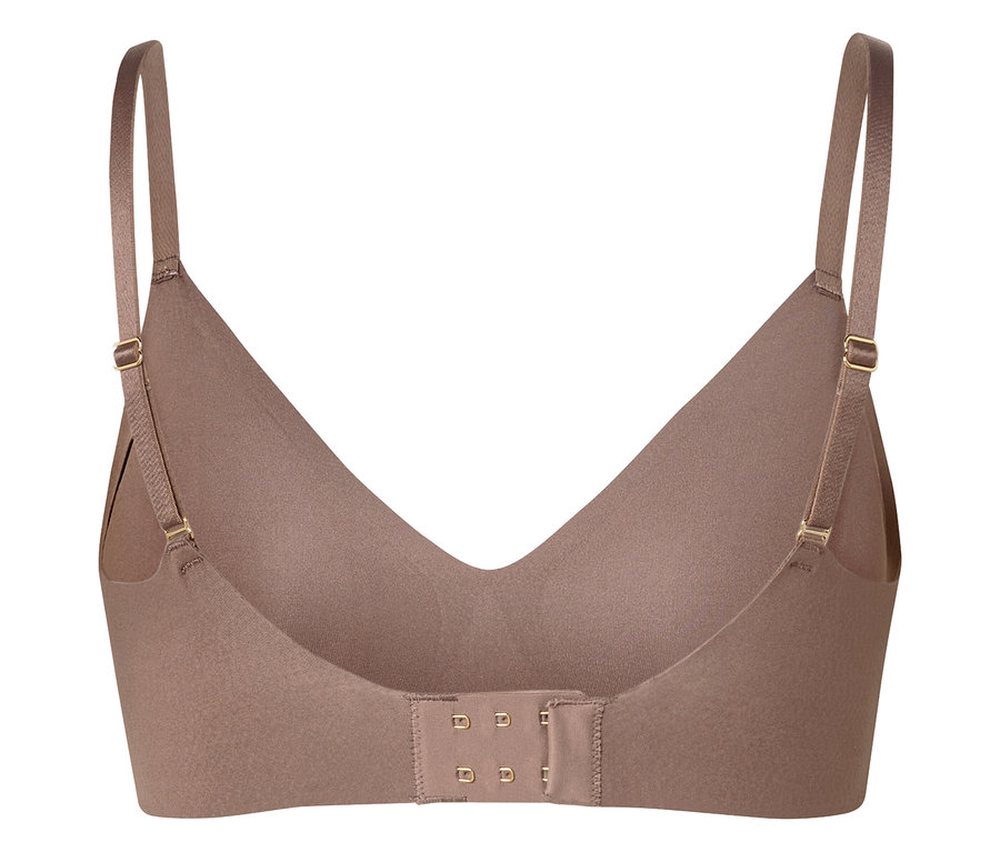Detailný záber béžovej podprsenky s nastaviteľnými ramienkami a háčikovým zapínaním na zadnej strane.