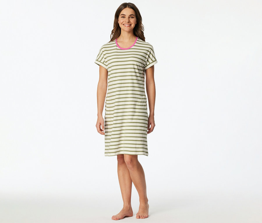 Žena stojí naboso a má na sebe pruhované tričkové šaty s ružovými akcentmi na krku.