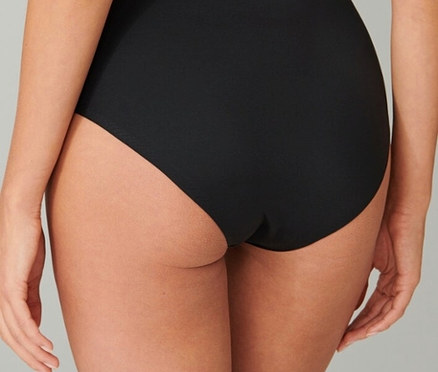 Pohľad zozadu na ženu v čiernych nohavičkách.