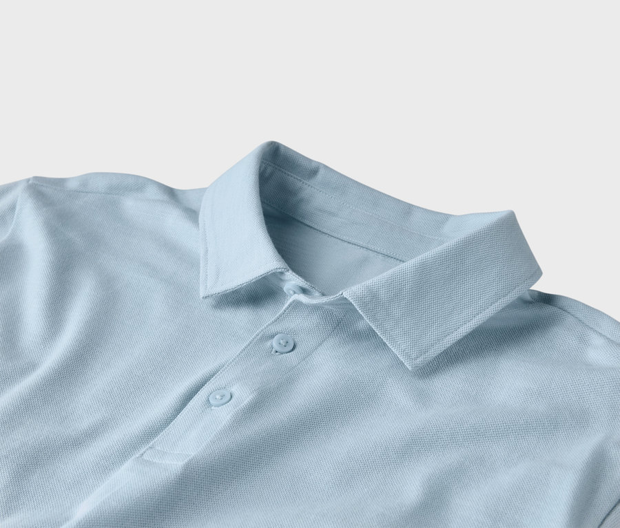 Detailný záber na svetlomodré polo tričko s golierom a dvoma gombíkmi.