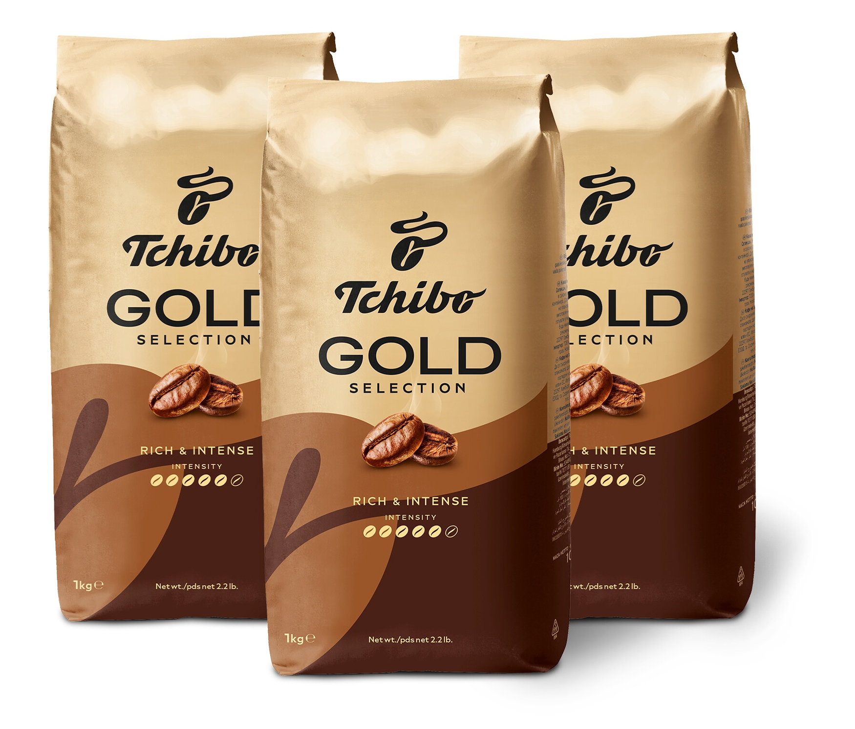 Tri balenia kávy Tchibo Gold Selection stoja na bielom pozadí.