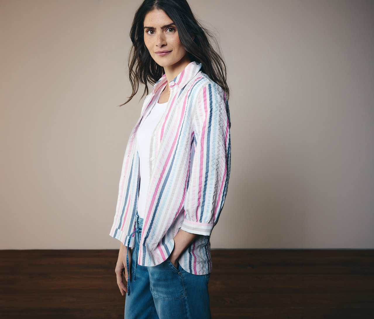 Žena v pásikavej košeľovej blúzke CECIL s 3/4 rukávmi a džínsoch. Jednu ruku má vo vrecku.