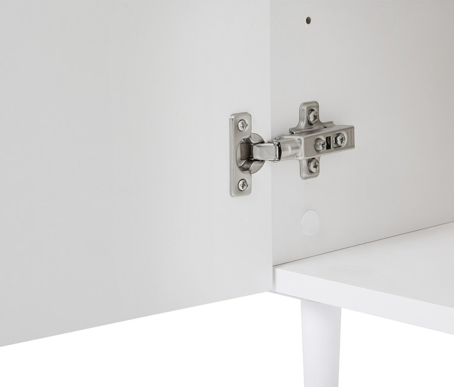 Detailný pohľad na bielu skrinku so strieborným pántom pripevneným k dverám.