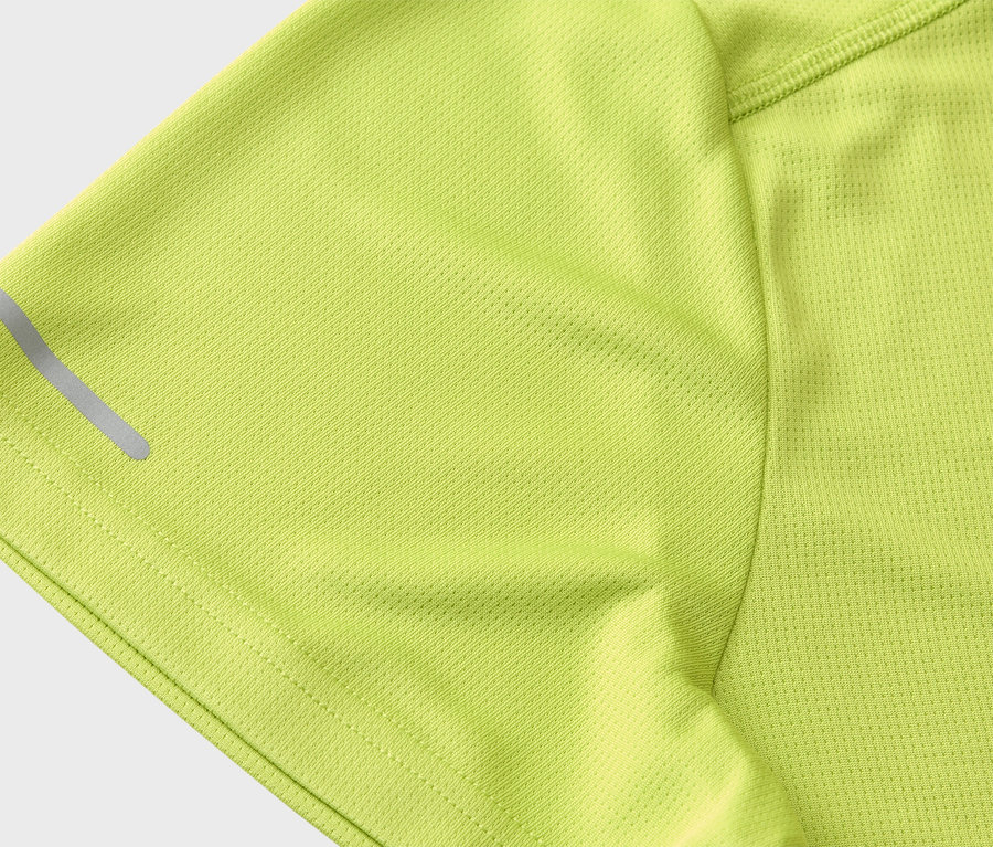 Detailný záber na rukáv svetlozeleného športového trička s reflexným pásikom.