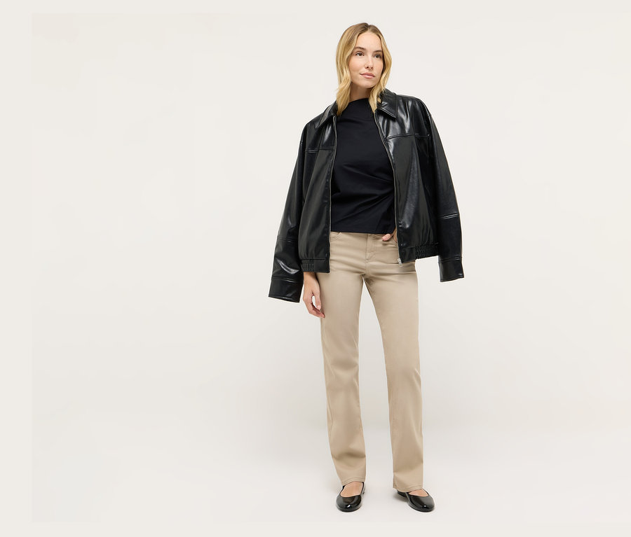 Blondínka stojí a má na sebe čiernu bundu a rifle Angels Denim »Lara« Straight Fit.