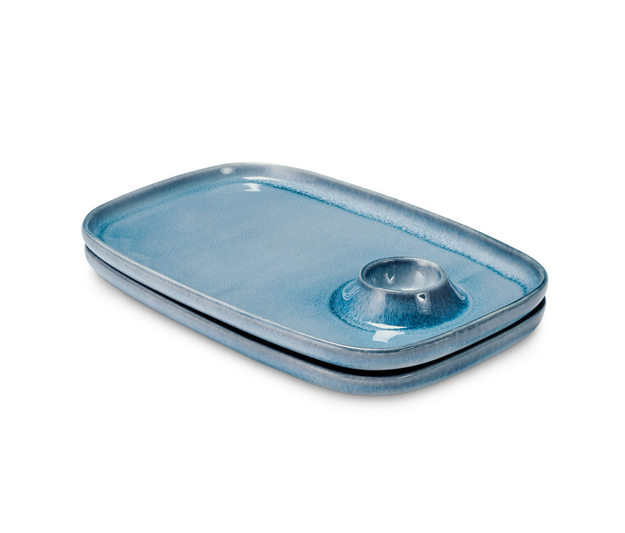 Dva modré raňajkové taniere s držiakom na vajcia.